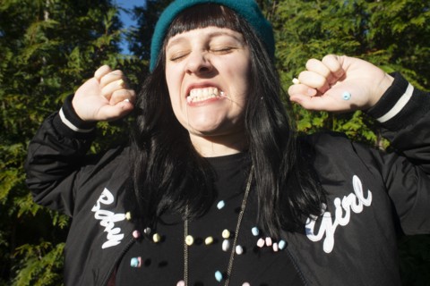 Young Adult Woman Eating Candy Necklace