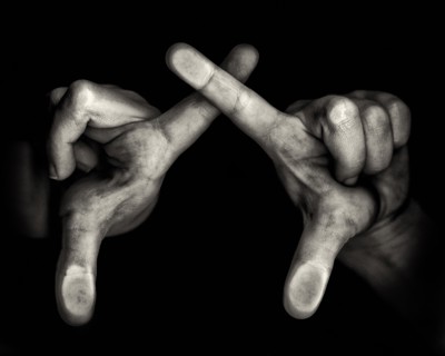 Two Hands with Crossing Forefingers on Black Background