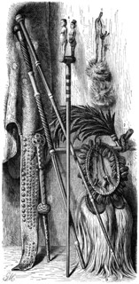 South African Native items: 1, 2 Chieftan's Staffs; 3, Dancing Staff; 4, Fetish Stick; 5, Mantle Cloth with Trailing Ornamentation; 6, Fly Brush worn on Head; 7, Plume of Feathers; 8, Collar for Danci...