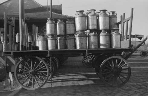 Milk cans at Railroad station. Minot