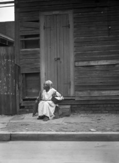 Female Praline Vendor sitting on Steps holding a Basket