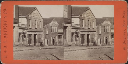 Man with Rifle sitting outside Commercial Building used as Slave Market