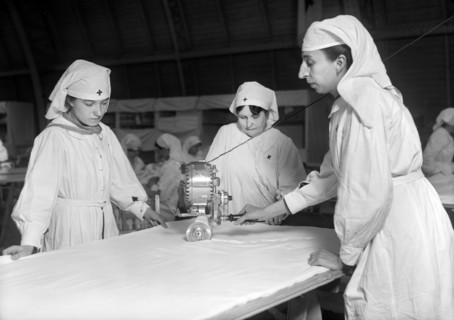 Female American Red Cross Workers cutting Unbleached Muslin for Bias Bandages with Cutting Machine in American Red Cross Workroom for making Surgical Dressings
