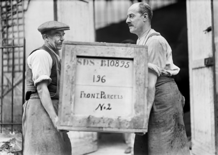 Two Men carrying Box filled with American Red Cross Supplies labeled "Front Parcels" to be delivered to the Front Lines of War