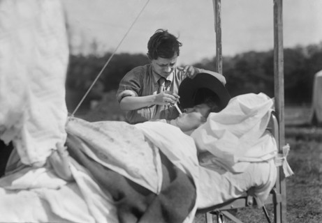 American Red Cross Boy Scout lighting Cigarette for Soldier unable to help himself in Hospital near Paris