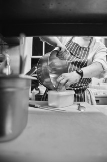 Chef putting Grated Cheese in Plastic Container
