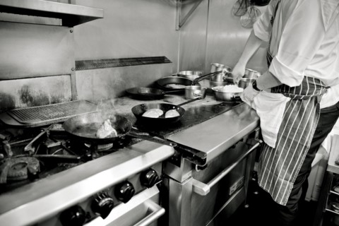 Chef putting Grated Cheese in Plastic Container