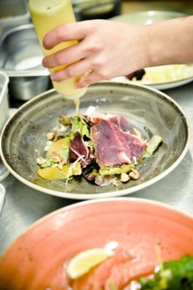 Chef drizzling Oil on Salad