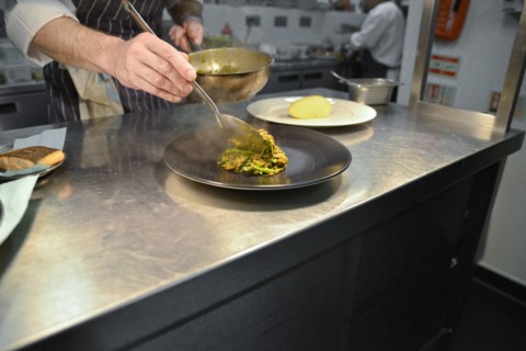 Chef spooning Lentils onto Plate