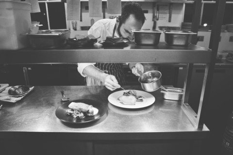 Chef plating Food in Restaurant Kitchen