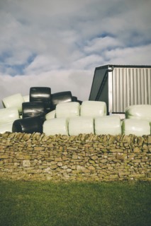Wrapped Bales of Hay behind Old Stone Wall