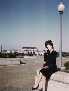 Woman putting on Lipstick in Park with Union Station in Background