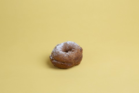 Doughnut with Powdered Sugar on Yellow Background