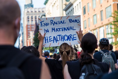 Crowd of Protesters with Signs, "End Racial Bias in Maternal Healthcare",
