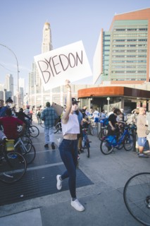 Woman walking in Crowd with "Byedon" Sign outside Barclays Center during Celebration of President-Elect Joe Biden, Brooklyn