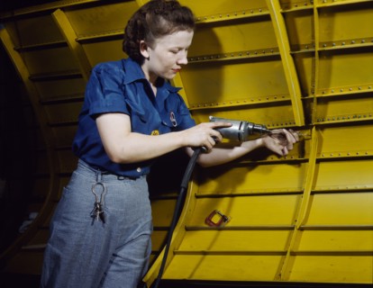 Woman operating hand drill on "Vengeance" dive bomber