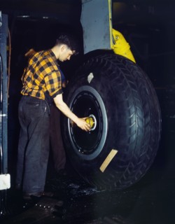 Worker inspecting landing wheel of Transport Plane