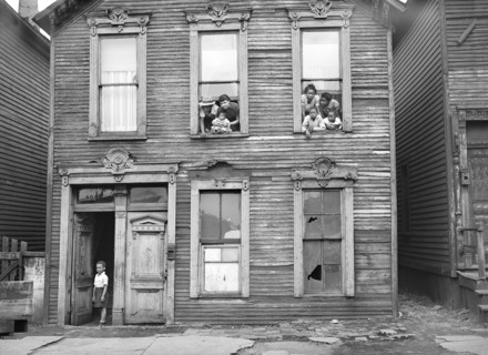 Group of People looking out of windows in rundown House