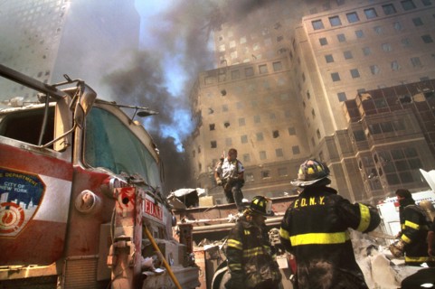 New York City Fire Fighters amid debris with smoldering ruins in background