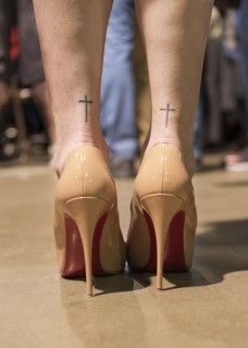 Rear View of High Heel Shoes and Cross on Woman's Ankles
