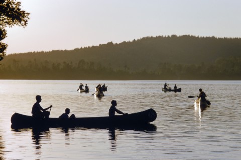 Silhouette of boys in Canoe Boats at Sunset