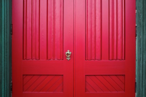 Red Wood Doors with Ornate Metal Handle