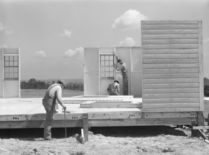 Construction workers building prefabricated houses for tenant farmers being relocated due to construction of Camp Croft
