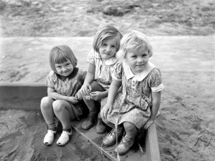 Three children playing in sandbox