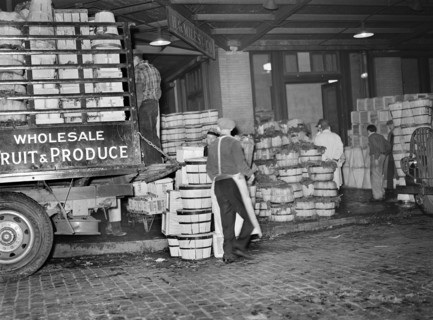 Workers loading green vegetables at produce market