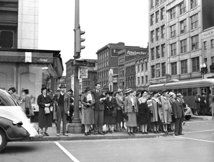 Pedestrians waiting at stoplight to cross street