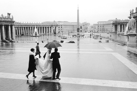 Bride and others crossing St. Peter's Square in the rain