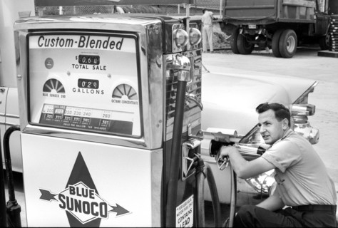 Gas station attendant filling car tank with custom blended gas at Sunoco gas station