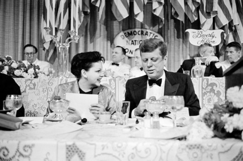 Actress Judy Garland seated next to U.S. Senator John F. Kennedy at dinner