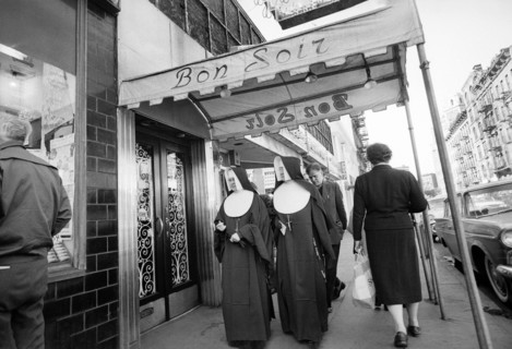 Two nuns walking under entrance canopy to Bon Soir nightclub
