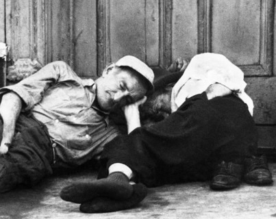 Two men lying down on sidewalk