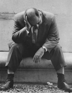 Man sitting with head resting on hand