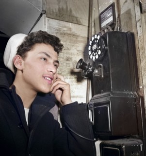 16-year-old teen boy who is in U.S. Naval Reserve talking on pay telephone, New York City, New