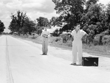 Two young men waiting for a ride on rural road, Natchitoches, Louisiana, USA, Marion Post Wolcott,