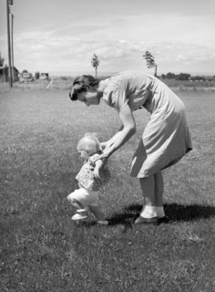 Farm worker's wife teaching her baby girl to walk, FSA (Farm Security Administration) labor camp,