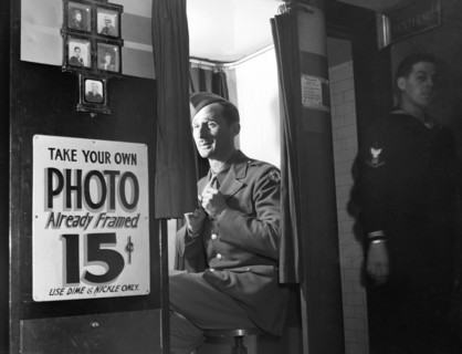 Man in military uniform sitting in  picture-taking machine in lobby at United Nations service