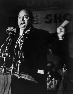 James Farmer, American civil rights activist, speaking before microphones outside Hotel Theresa,