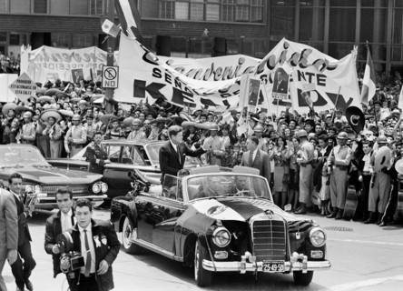 U.S. President John F. Kennedy waving to crowd from convertible car during motorcade to Los Pinos,