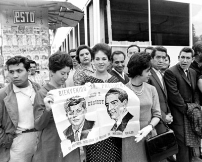 Spectators holding sign to greet U.S. President John F. Kennedy during his motorcade to Los Pinos,