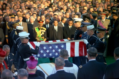Officials and foreign dignitaries look on as honor guard pallbearers fold the casket flag during