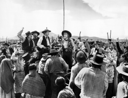 Regis Toomey (standing left of center), Jean Arthur (standing center), on-set of the western film,