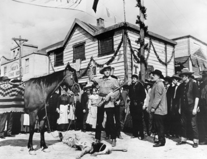 Stewart Granger (standing center with rifle), on-set of the western film, "Flaming Frontier",