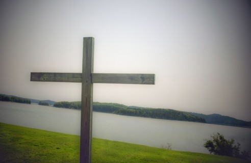 Wood cross on grass overlooking bay, Castine, Maine, USA