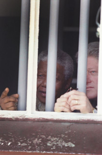 U.S. President Bill Clinton and South African President Nelson Mandela looking out from Cell Block