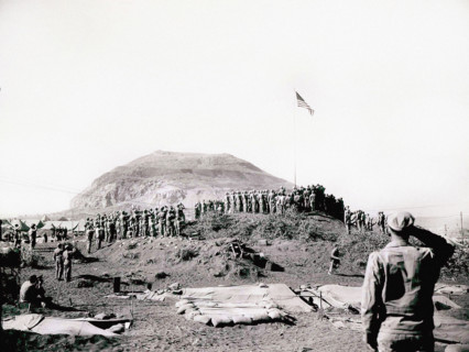 U.S. Marines of Fifth Marine Division raise American flag up flagpole after battle was won, Mount