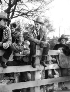 Robert Montgomery (center, sitting on fence), on-set of the western film, "Lovers Courageous", MGM,